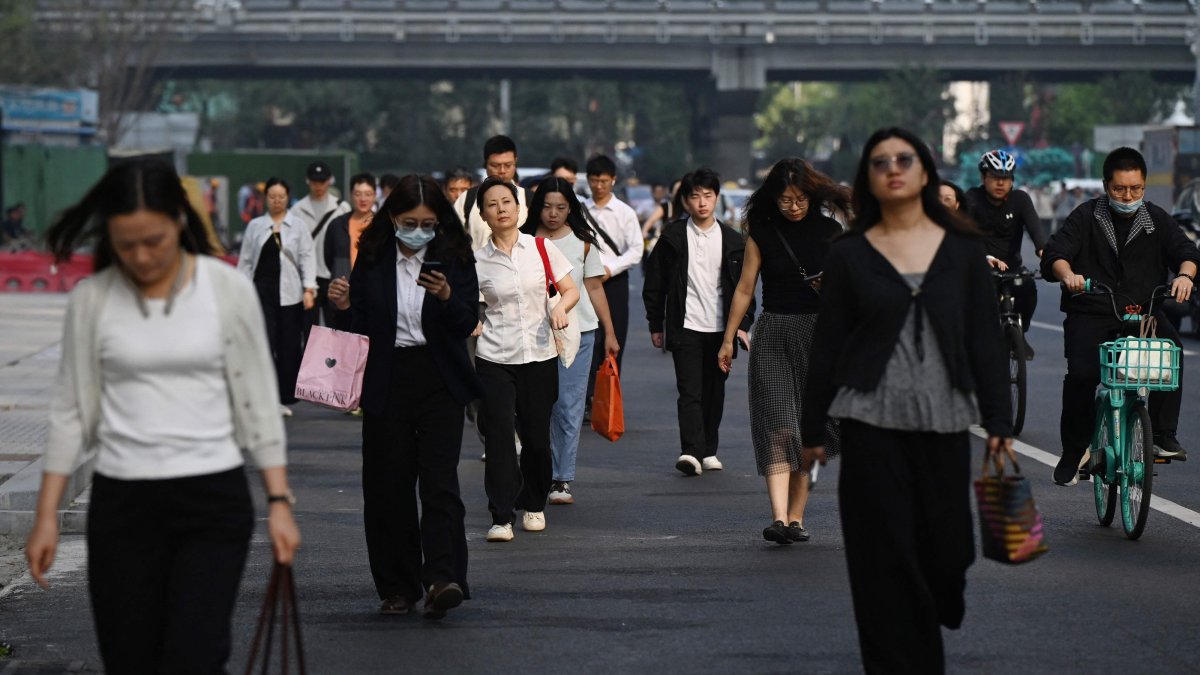 Office workers walk to their buildings in the central business district, Beijing, China, Sept. 23, 2026. (AFP Photo)