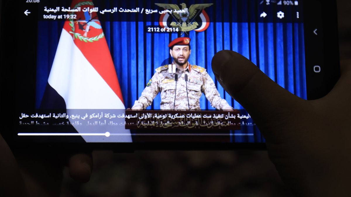 A person watches a video of Houthi military spokesperson Yahya Saree delivering a statement on a mobile phone in Sana'a, Yemen, Oct. 19, 2026. (EPA Photo)