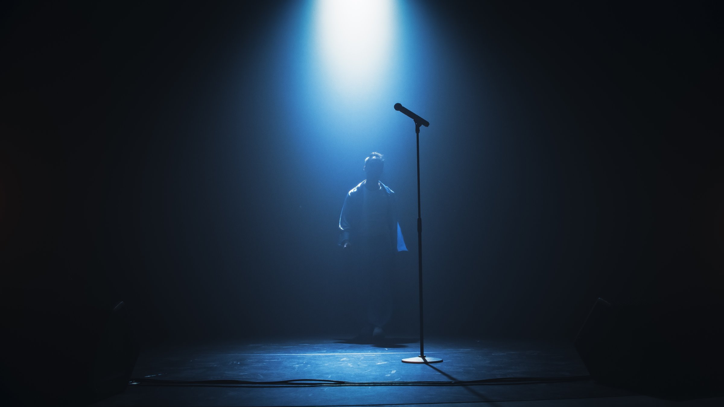 A silhouette of a singer on stage under the spotlight. (Shutterstock Photo)