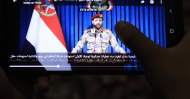 A person watches a video of Houthi military spokesperson Yahya Saree delivering a statement on a mobile phone in Sana'a, Yemen, Oct. 19, 2026. (EPA Photo)