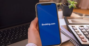The Booking.com app logo is seen on a phone screen. (Shutterstock Photo)