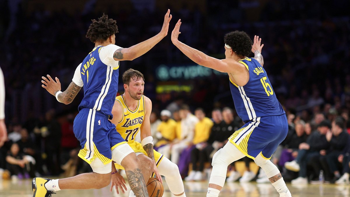 Golden State Warriors' Yaxel Lendeborg (L) and Gui Santos (R) defend against Los Angeles Lakers' Luka Doncic during the first half at Crypto.com Arena, Los Angeles, U.S., Oct. 21, 2026. (AFP Photo)