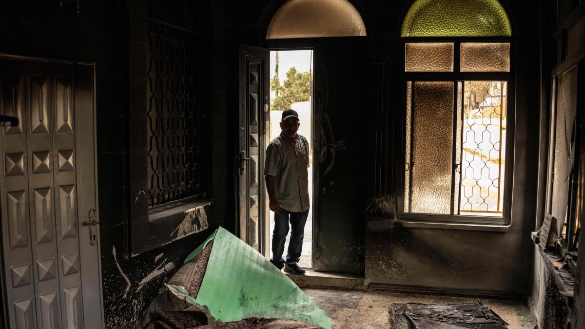 A Palestinian man assesses the damage at a mosque following an arson attack by Israeli terrorist settlers in Mikhmas, in the Israeli-occupied West Bank, Oct. 14, 2026. (AFP Photo)