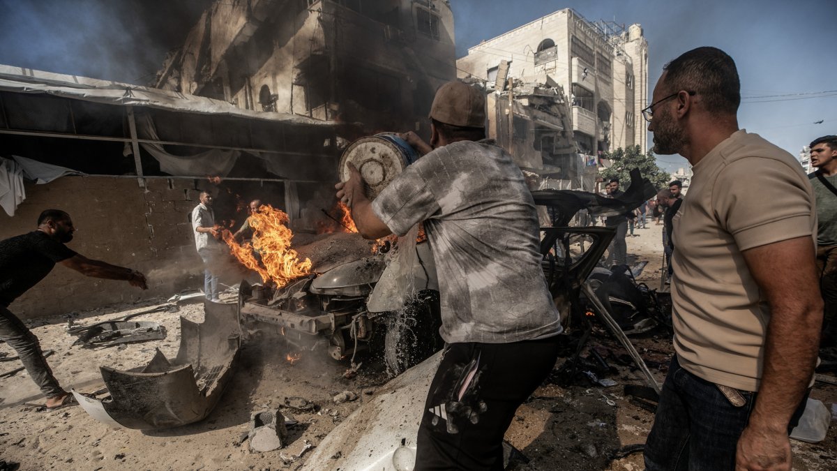Palestinians attempt to extinguish a fire in a vehicle destroyed in an Israeli airstrike south of Gaza City, Palestine, Oct. 22, 2026. (EPA Photo)
