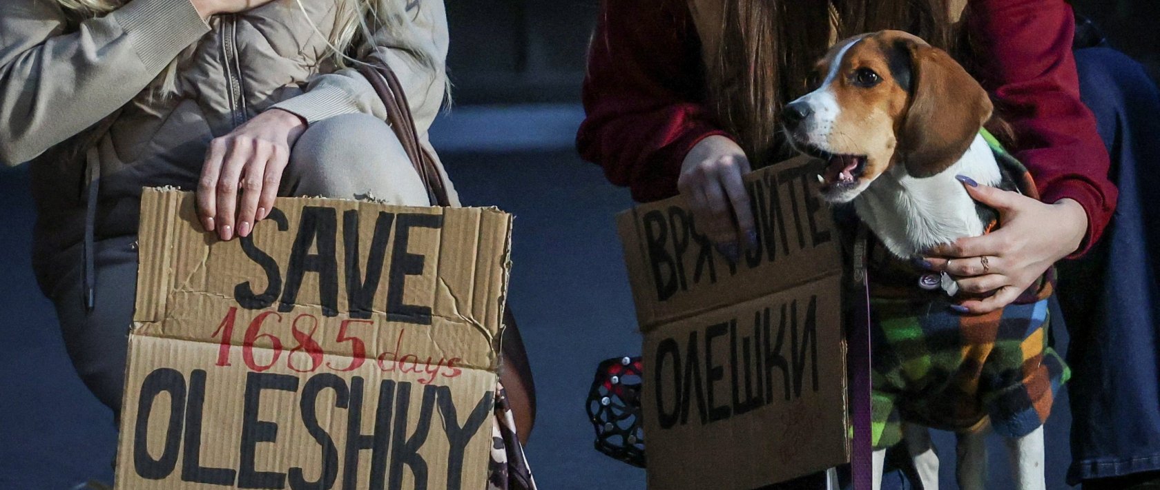 A dog looks on while women hold posters as they participate in a rally demanding the establishment of a humanitarian corridor to evacuate Ukrainian civilians from the town of Oleshky in Kherson region, amid Russia's attack on Ukraine, in Kyiv, Ukraine, Oct. 6, 2026. (Reuters Photo)