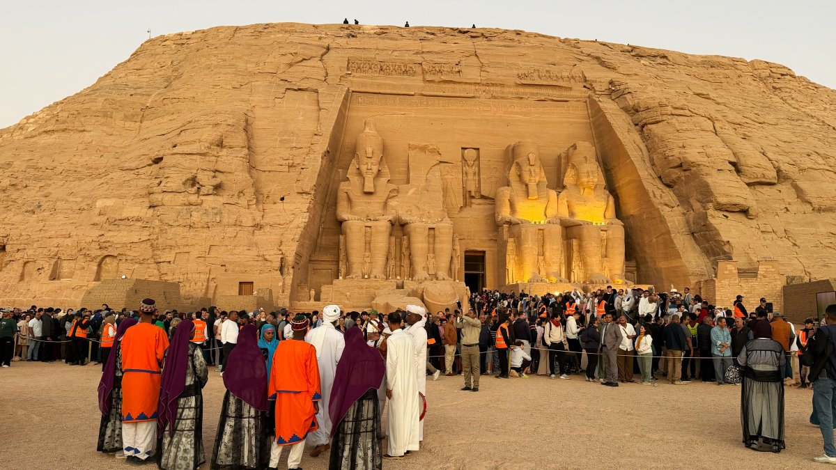 Tourists crowd to watch the sun as it sends a beam of light into the Great Temple of Ramses II's dark inner chamber, Abu Simbel, south of Cairo, Egypt, Oct. 22, 2026. (AP Photo)