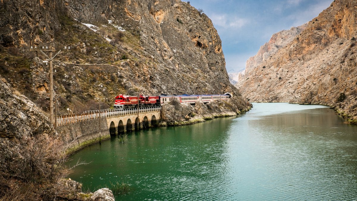 An undated view of the Touristic Eastern Express traveling through a mountainous landscape alongside a body of water. (DHA Photo)