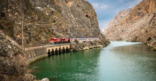 An undated view of the Touristic Eastern Express traveling through a mountainous landscape alongside a body of water. (DHA Photo)