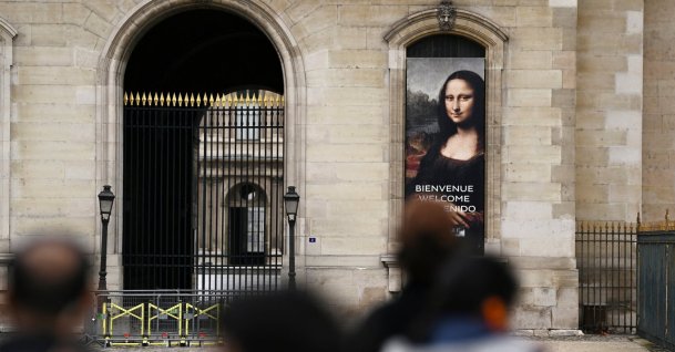 People stand in front of a poster depicting the "Mona Lisa" in front of the Louvre Museum, which is closed all day due to the fears of renewed turmoil in Paris ahead of nationwide protests, Paris, France, Oct. 24, 2026. (Reuters Photo)