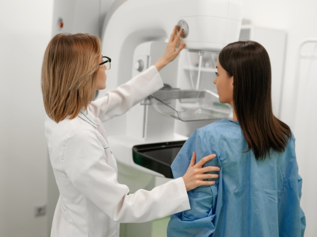 A doctor assists a patient during a mammography screening for early breast cancer detection. (Shutterstock Photo)