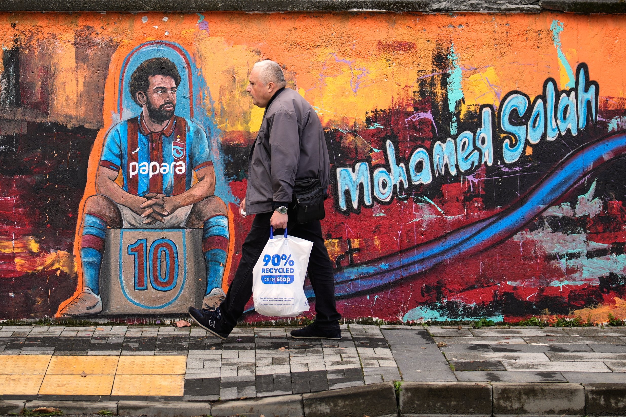A man walks past a mural depicting Trabzonspor's Egyptian footballer Mohamed Salah in Trabzon, Tükiye, Oct. 19, 2026. (AP Photo)