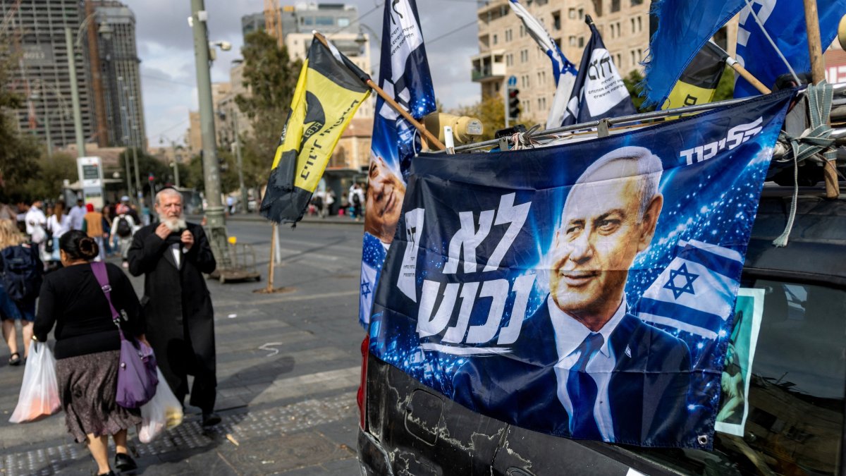People walk past a sign featuring an image of Israeli Prime Minister Benjamin Netanyahu at a market, ahead of Israel's national election, Jerusalem, Oct. 16, 2026. (Reuters Photo)