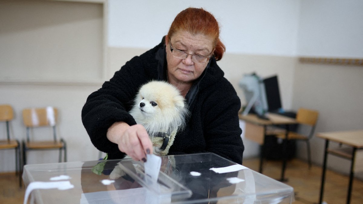 A woman carries a dog as she votes during the presidential election, in Sofia, Bulgaria, Oct. 25, 2026. (Reuters Photo)