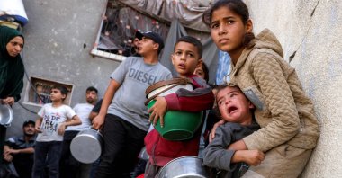 Children react as people take cover from a reported drone strike while they were queueing to receive meals from a charity kitchen in the Jabalia camp for Palestinian refugees in the northern Gaza Strip, Oct. 24, 2026. (AFP Photo)