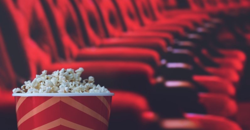 Popcorn rests on a red armchair in a movie theater. (Shutterstock Photo)