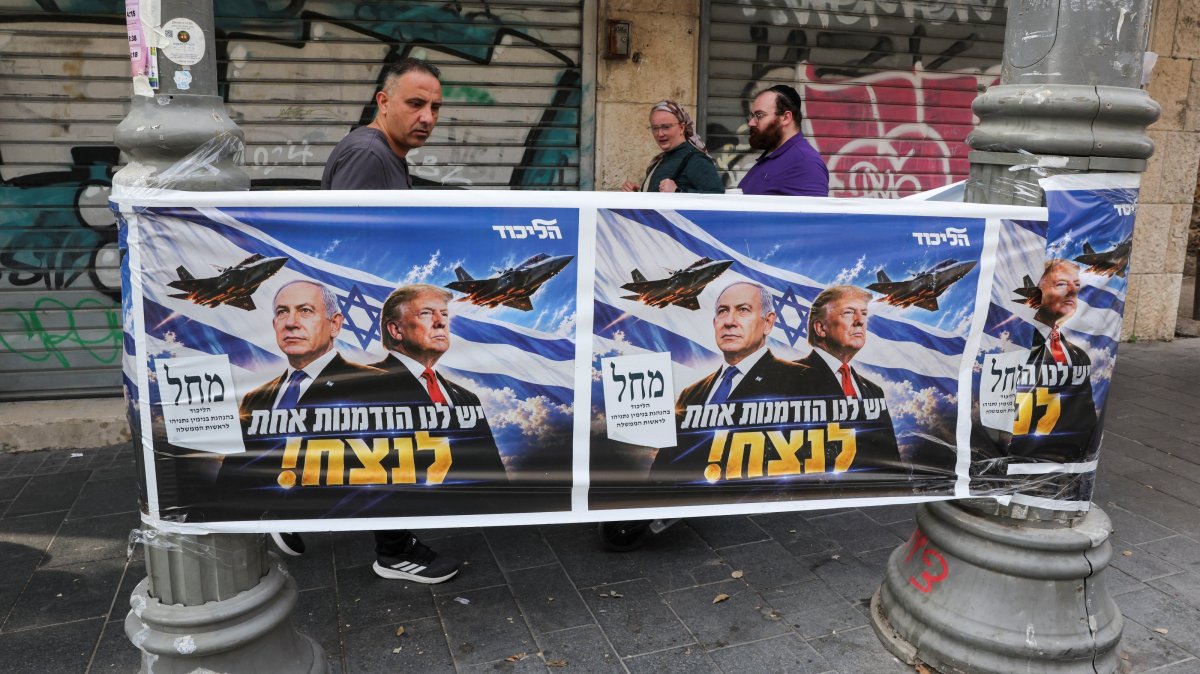 People walk past a poster of Israeli Prime Minister and Likud party leader Benjamin Netanyahu and U.S. President Donald Trump during the country's national elections in central Jerusalem, Oct. 27, 2026. (Reuters Photo)