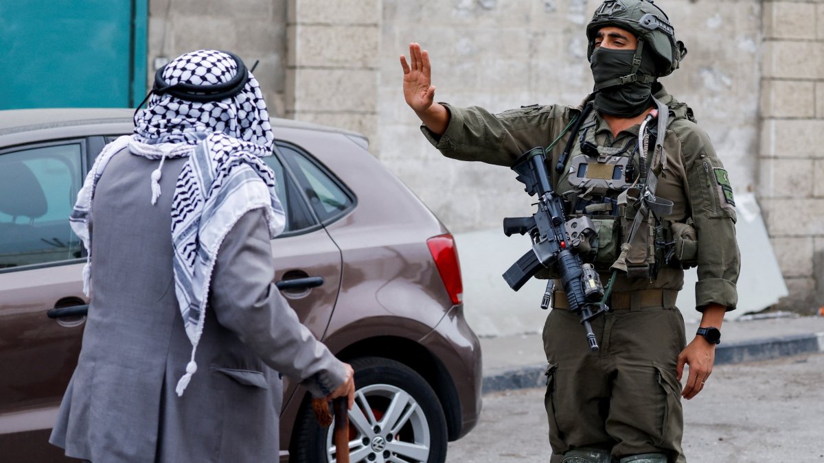 An Israeli soldier gestures toward a Palestinian man during a protest of residents against their displacement from a neighborhood, amid ongoing Israeli military operations, in Hebron, in the Israeli-occupied West Bank, Palestine, Oct. 27, 2026. (Reuters Photo)