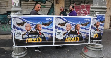 People walk past a poster of Israeli Prime Minister and Likud party leader Benjamin Netanyahu and U.S. President Donald Trump during the country's national elections in central Jerusalem, Oct. 27, 2026. (Reuters Photo)