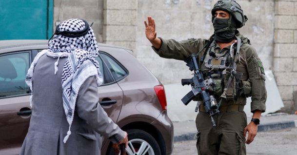 An Israeli soldier gestures toward a Palestinian man during a protest of residents against their displacement from a neighborhood, amid ongoing Israeli military operations, in Hebron, in the Israeli-occupied West Bank, Palestine, Oct. 27, 2026. (Reuters Photo)