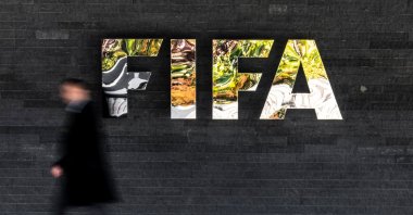 A man walks past a FIFA sign at the headquarters during the FIFA council meeting, Zurich, Switzerland, Oct. 15, 2026. (AP Photo)