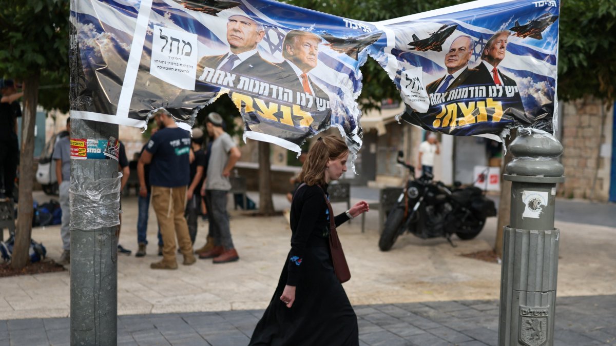 A woman passes by a banner depicting Israeli Prime Minister Benjamin Netanyahu and U.S. President Donald Trump the day after the country held a national election, Jerusalem, Oct. 28, 2026. (Reuters Photo)