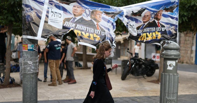 A woman passes by a banner depicting Israeli Prime Minister Benjamin Netanyahu and U.S. President Donald Trump the day after the country held a national election, Jerusalem, Oct. 28, 2026. (Reuters Photo)