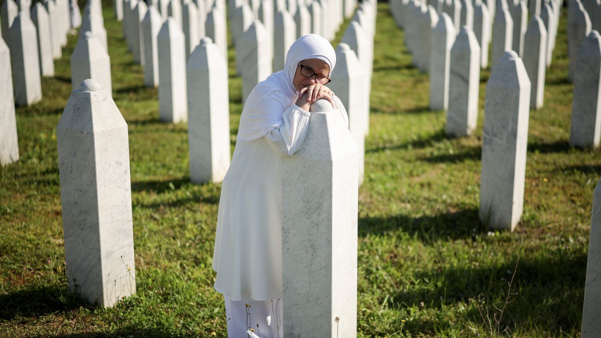 A Bosnian woman mourns next to the grave of her relative, a victim of the Srebrenica genocide, in the Srebrenica Memorial Center, Potocari, Bosnia-Herzegovina, July 11, 2026. (AP Photo)