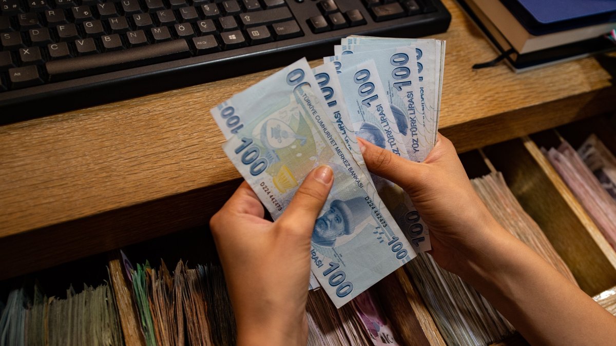 A currency exchange office worker counts Turkish lira banknotes at an exchange office in Istanbul, Türkiye, Aug. 6, 2020. (AFP Photo)