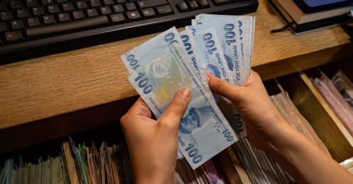 A currency exchange office worker counts Turkish lira banknotes at an exchange office in Istanbul, Türkiye, Aug. 6, 2020. (AFP Photo)